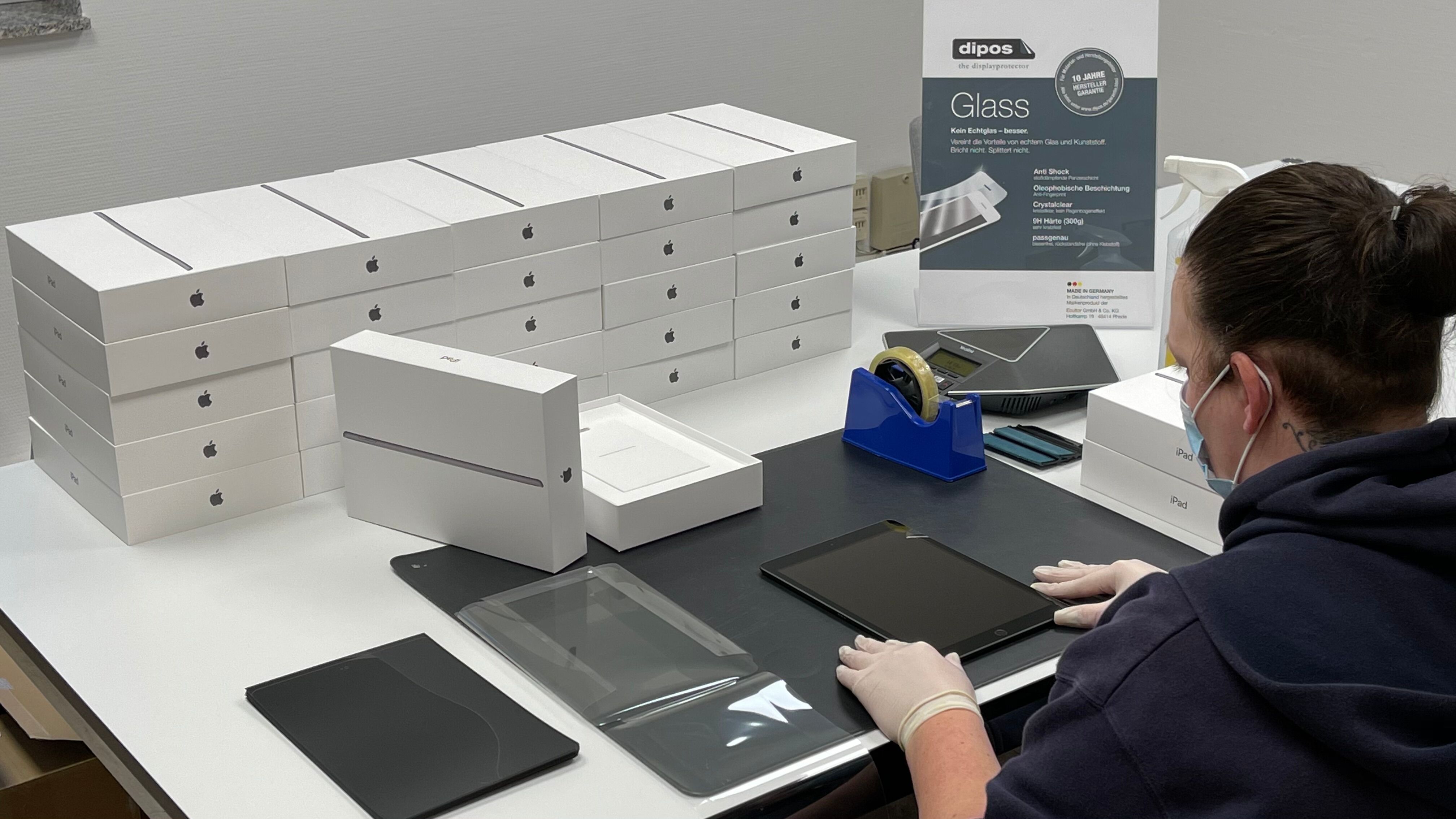 Im Kundenauftrag werden 100 Apple iPads mit der dipos Glass Displayschutzfolie laminiert.